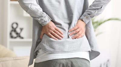 Young man suffering from back pain at home Young man suffering from back pain at home